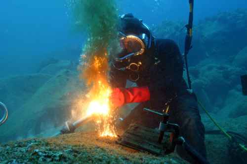 Underwater burning, shot with divers on safety